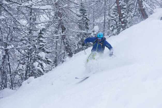 freeride skier skiing in deep powder snow