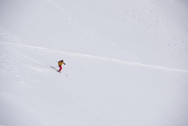 лыжник-фрирайдер катается на лыжах по глубокому рыхлому снегу