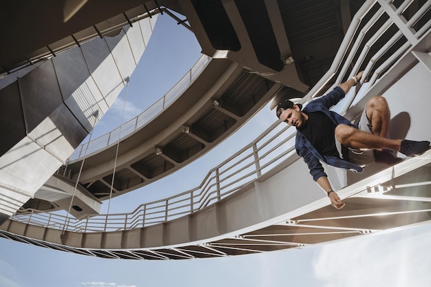 Freerunning-atleet hangt aan de brug en maakt zich klaar voor een gevaarlijke sprong