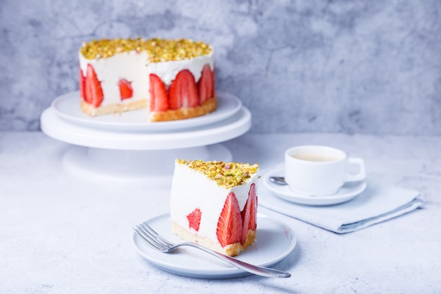 Freesier cake with fresh strawberries and pistachios. French classic dessert. Portion of cake on a white plate close-up.