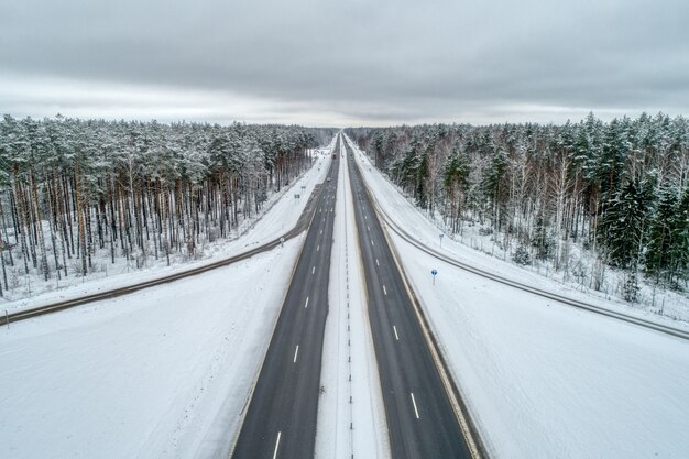 Автострада, проходящая через зимний лес.