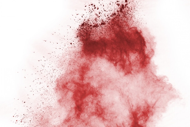 Photo freeze motion of red powder exploding, isolated on white background.