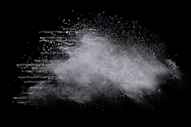 Photo freeze motion of white powder explosions isolated on black background.