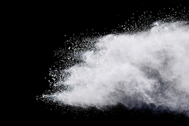 Photo freeze motion of white powder explosions isolated on black background.