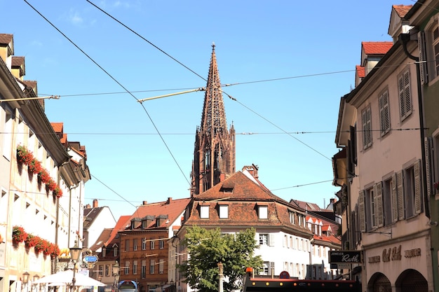 Foto freiburg munster visto da lontano con vecchi edifici che fiancheggiano la strada