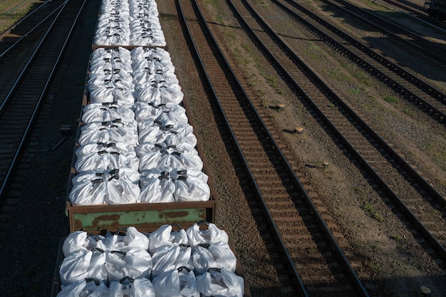 In the freight car of the train there are white large bags with\
fertilizers shipping fertilizer by rail transportation of\
fertilizers in huge bags and wagons by rail fertilizer cars freight\
train