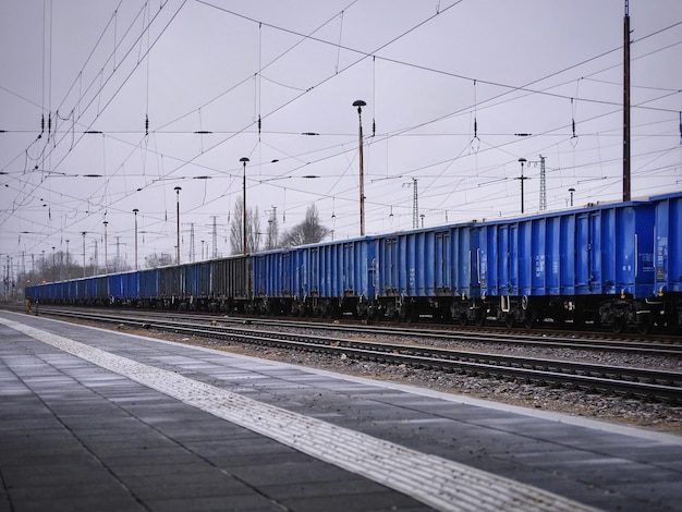 Фото Грузовой поезд на железнодорожных путях против неба