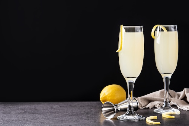 French 75 cocktail in glass on black slate background