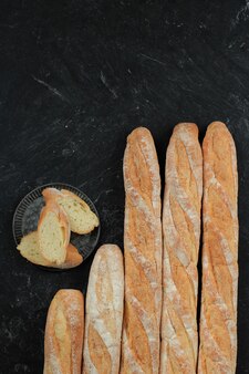 Pane per baguette francese su tavolo in marmo nero, vista dall'alto con spazio per la copia per il testo