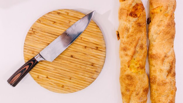 French baguettes on the table and bread knife lies on the board