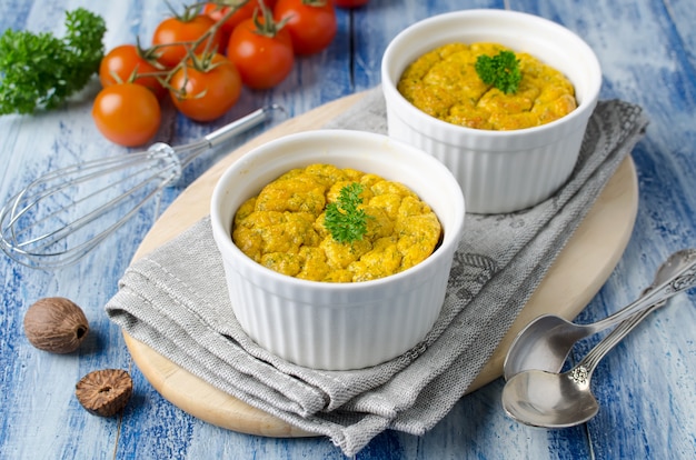 French baked cheese souffle with carrots and dill in white ramekin