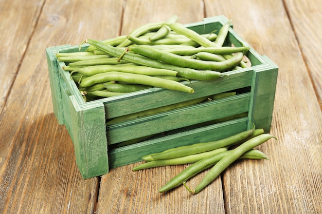 French beans in wooden box on table close-up