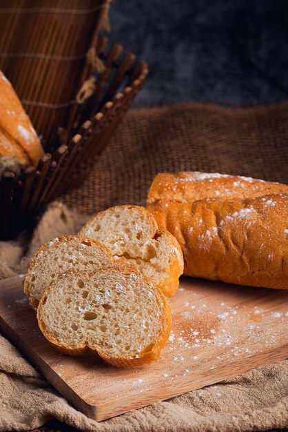 French bread sprinkled with icing sugar on a wooden chopping board