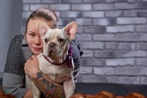 French bulldog on the hands of his master It is felt that the girl loves her pet and hugs and kiss him tightly