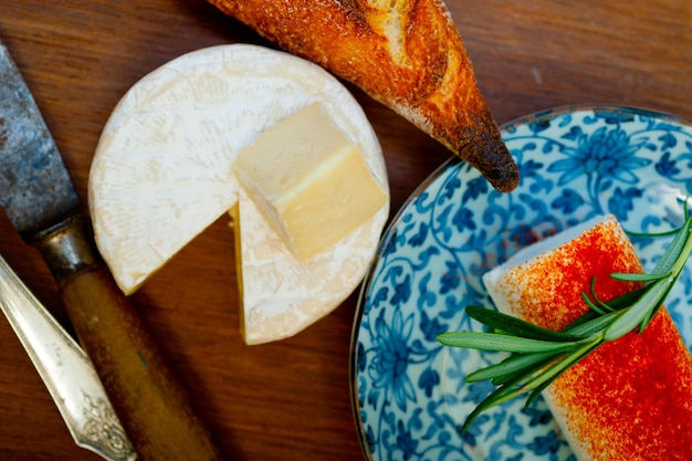 Photo french cheese and fresh baguette on a wood cutter