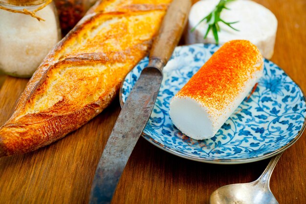 Photo french cheese and fresh baguette on a wood cutter