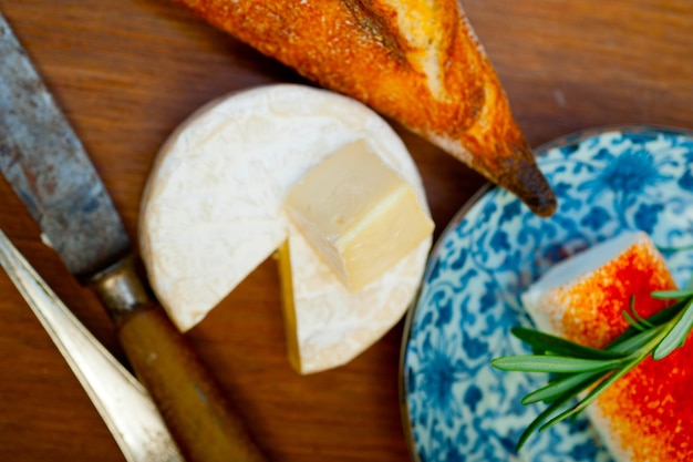 Foto formaggio francese e baguette fresca su un taglialegna