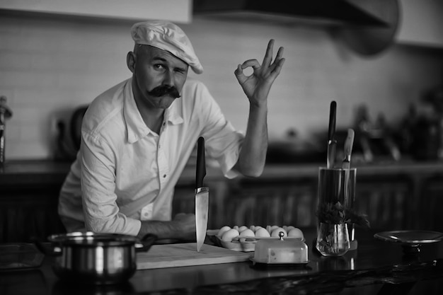 french chef in the kitchen preparing food, cooking, haute cuisine, man with mustache