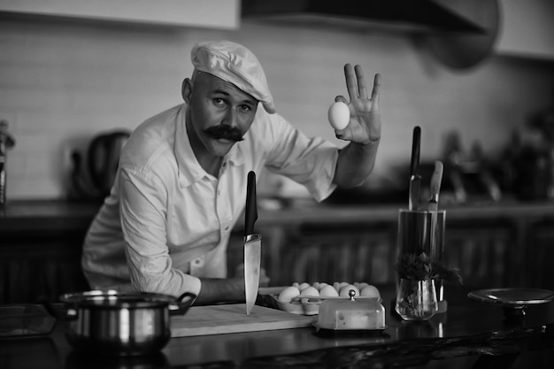 french chef in the kitchen preparing food, cooking, haute cuisine, man with mustache