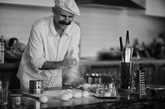 french chef in the kitchen preparing food, cooking, haute cuisine, man with mustache