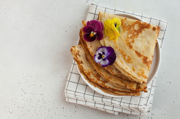 Foto crepes francesi, frittelle decorate con fiori. concetto di colazione, dessert .. cultura francese, maslenitsa