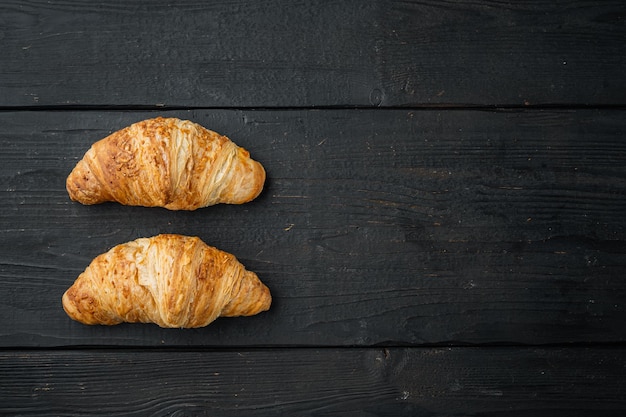 French croissant on black wooden table background top view flat lay with copy space for text