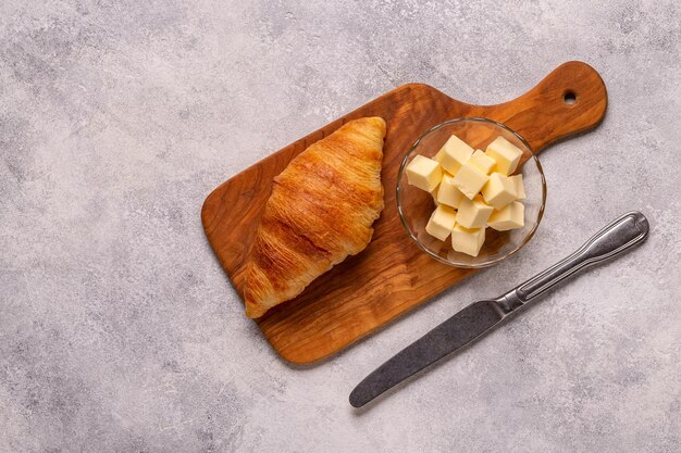 フランスのクロワッサン暗い石の背景にバターを添えた焼きたてのクロワッサン