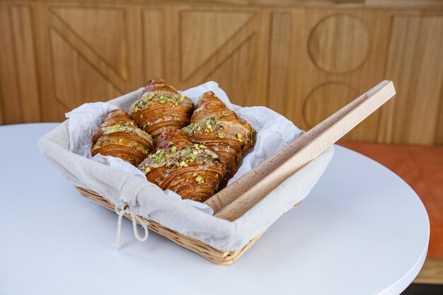 French croissants in wicker basket on table