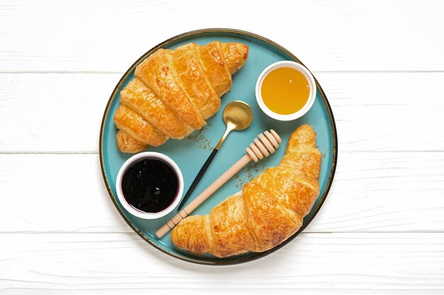 French croissants with chocolate on blue plate