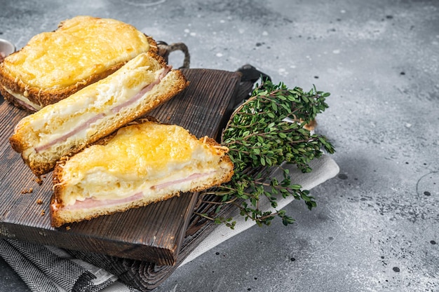 Французский сэндвич Croque Monsieur с сыром, ветчиной, грюйером и соусом бешамель. Серый фон. Вид сверху. Скопируйте пространство.