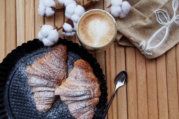 French crust croissants glass of latte outside Cozy time Pastel background with cotton decoration