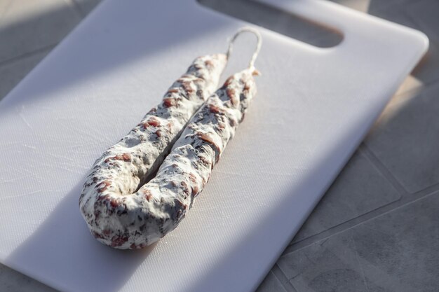 French cured sausage with white mold on cutting board