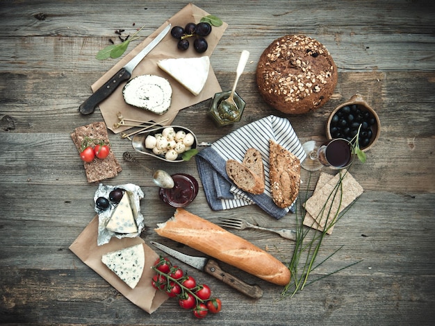 木製の背景にフランス料理、さまざまな種類のチーズワイン、木製のその他の食材