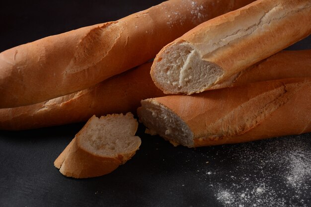 暗い背景にフランスの焼きたてのパンのバゲット