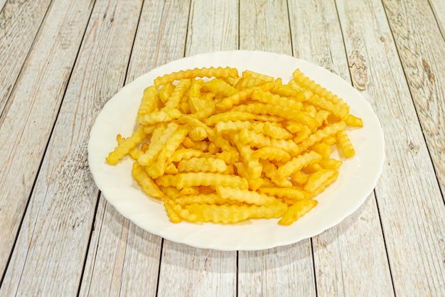 Photo french fries are prepared by cutting them into slices or sticks and frying them in hot oil until golden brown removing them from the oil and then seasoning them with salt