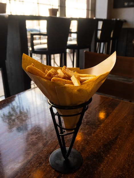 Foto patatine fritte in un cono in un caffè