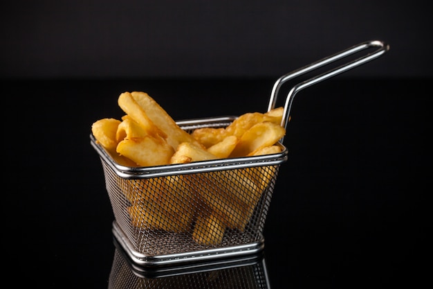 Photo french fries in an iron grid in the cart