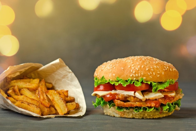 French fries and juicy meat burger with beef cheese tomatoes lettuce onion