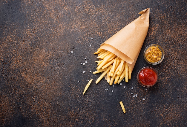 Patatine fritte in un sacchetto di carta con salse