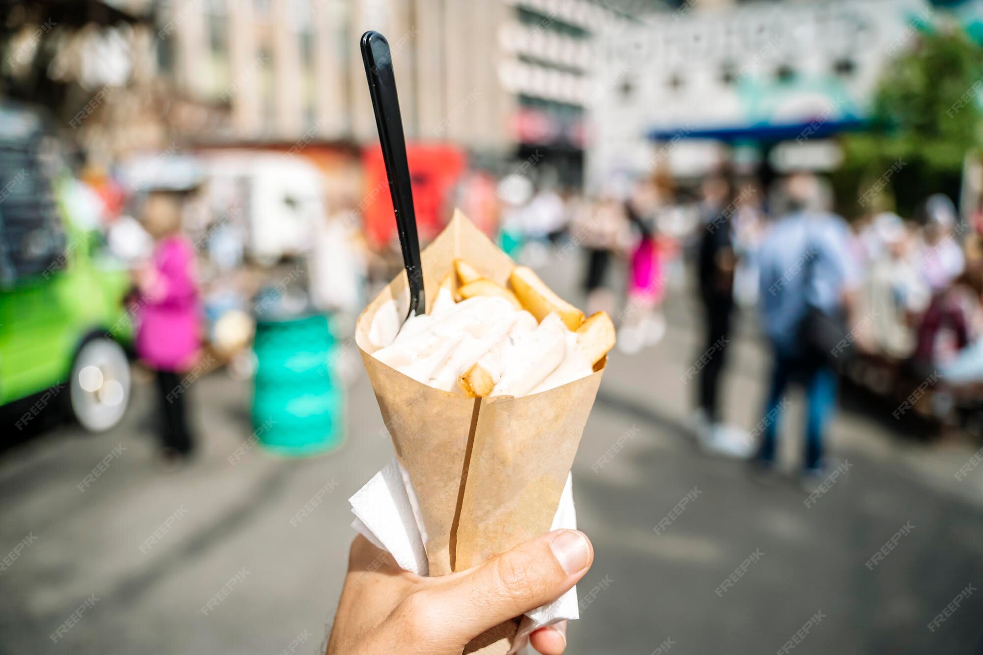 Premium Photo | French fries street food with sauce in hand on the