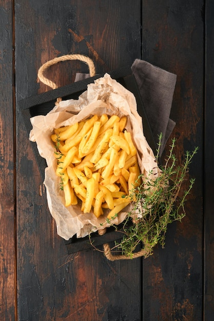 French fries Tasty French fries server on parchment paper on wooden cutting board with tomato and cheese sauce on old wooden table background Diverse Keto Dishes Fast food and unhealthy food concept