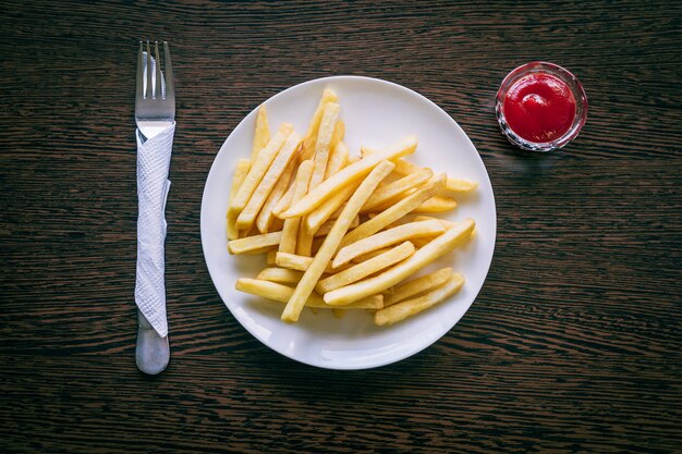 French fries on white plate with ketchup