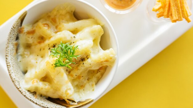 french fries with cheese on a yellow table.