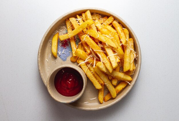 Photo french fries with ketchup and cheese on a plate