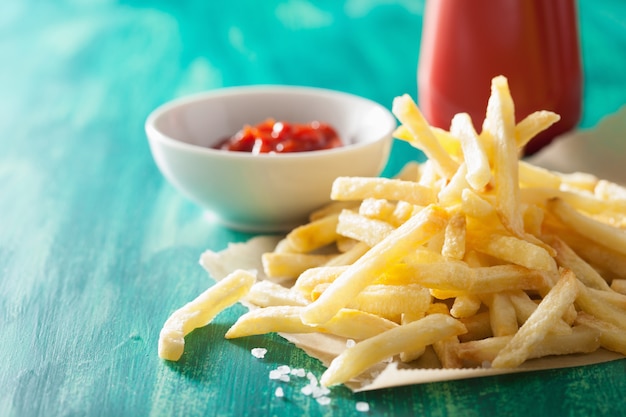 French fries with ketchup over green background