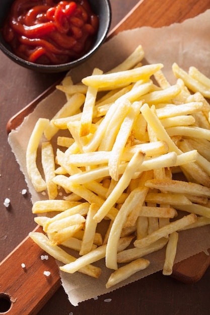 French fries with ketchup over rustic background