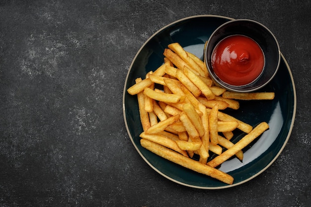 French fries with sauce on a plate on a dark background