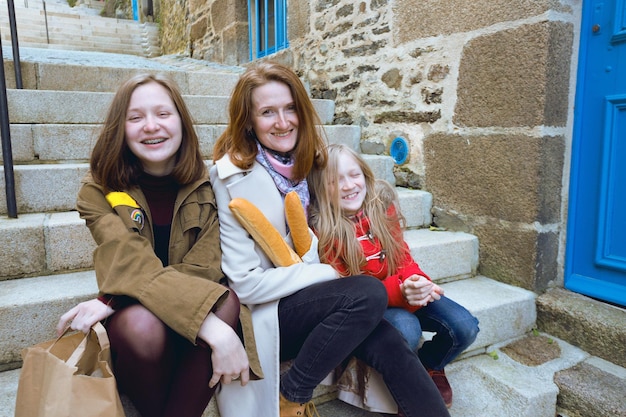 French happy mother and daughters with baguettes