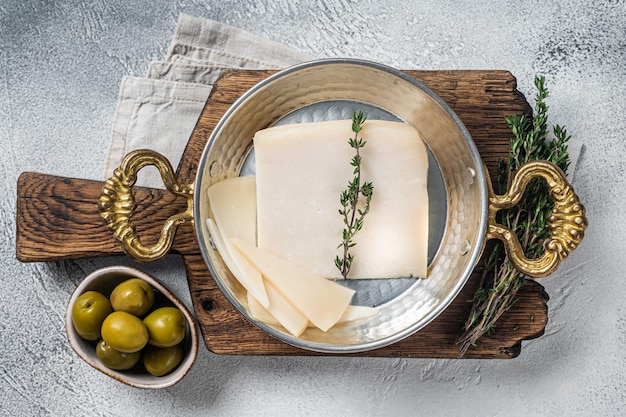 ハーブとフライパンでフランスのハードゴートチーズ白い背景上面図