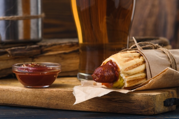 French hot dog with beer in rustic style. Street food.